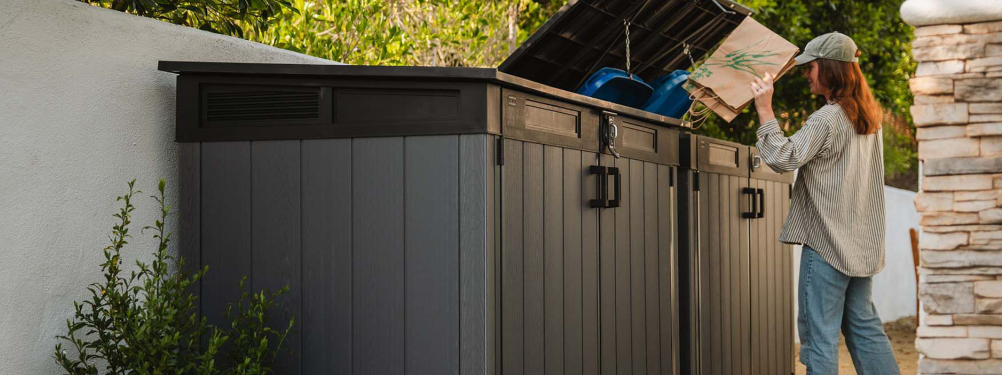 Woman using two waterproof outdoor storage box units for outdoor organisation