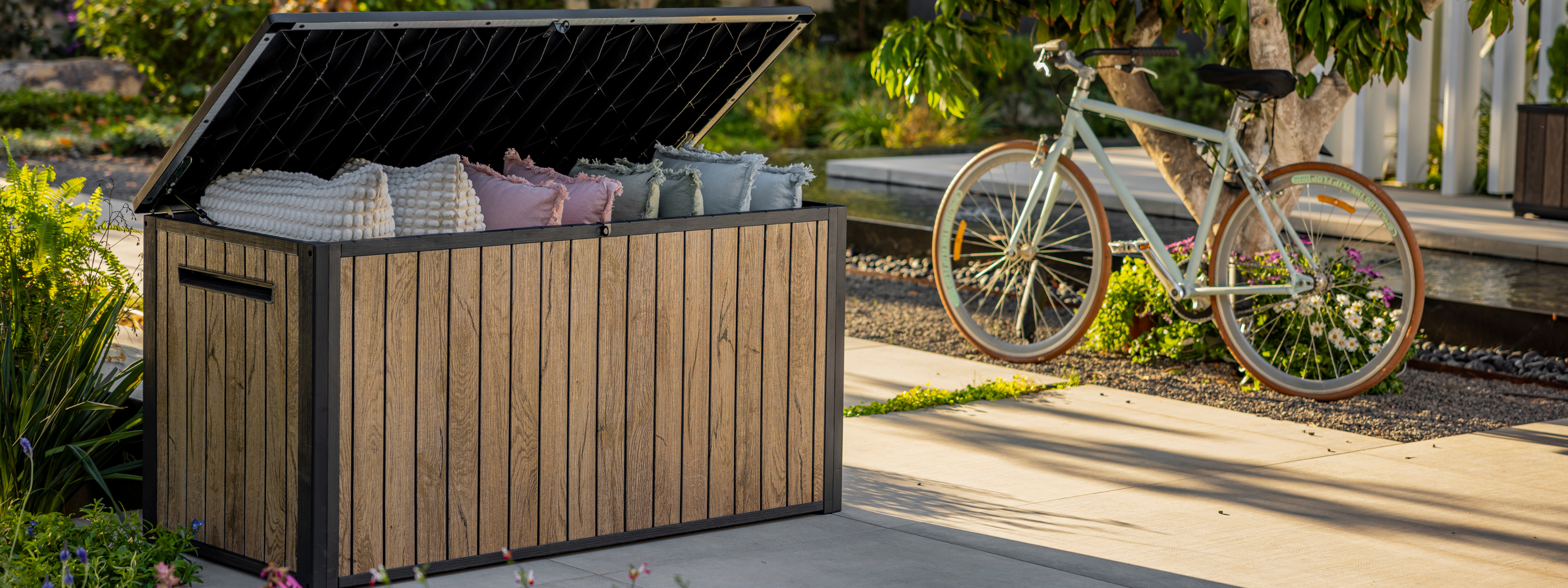 Wood-look Keter outdoor storage box in South Africa, weather-resistant storage solution for cushions and garden gear.