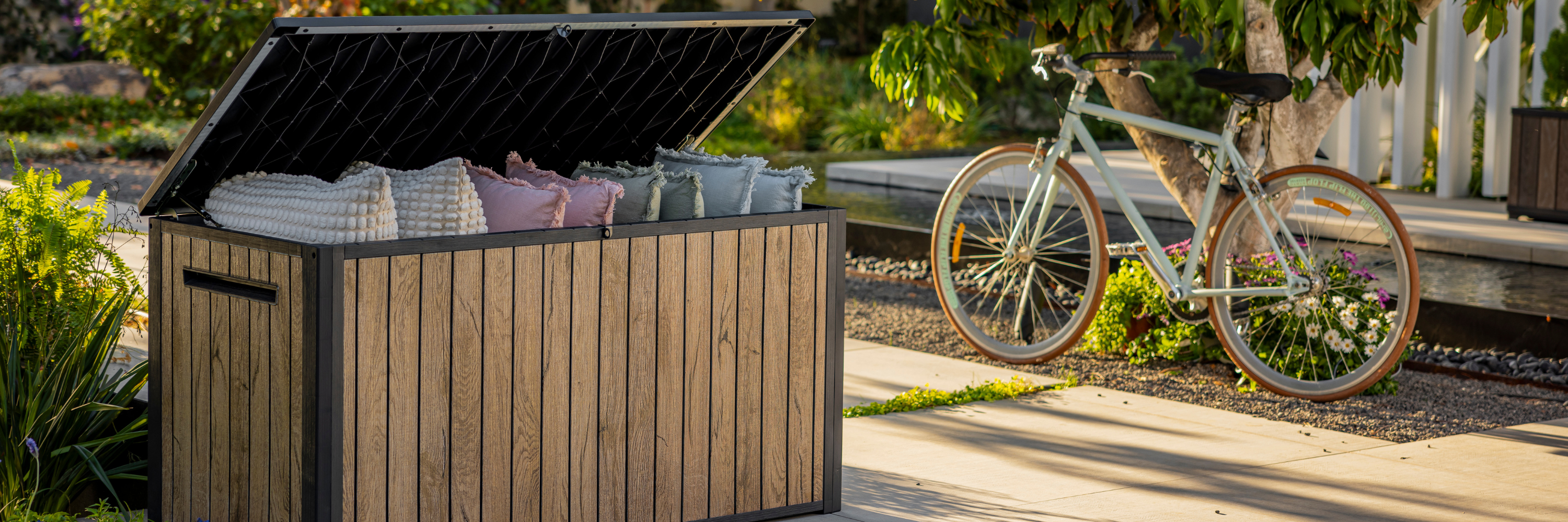 Outdoor storage box with wood-look finish on patio storing cushions and garden items