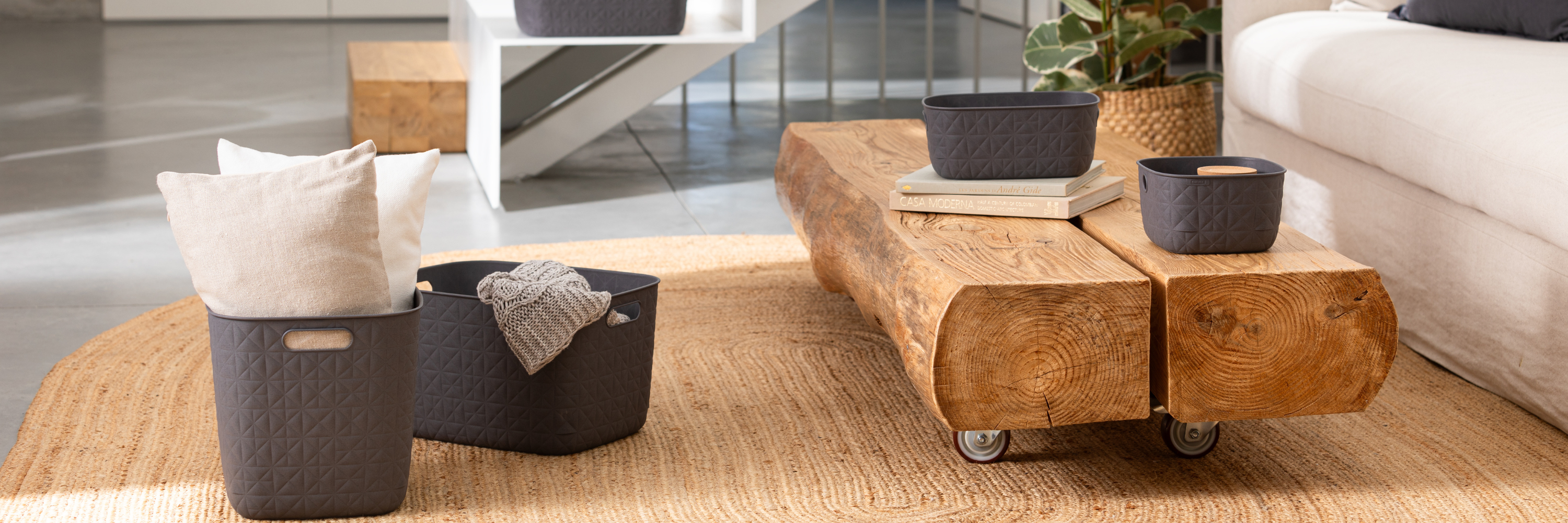 Lounge area with a wooden coffee table and grey storage baskets placed on the floor