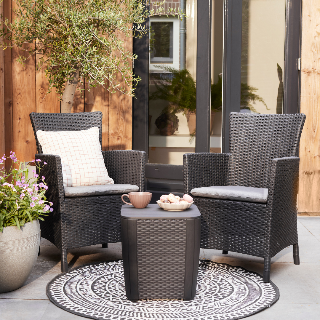 Iowa Balcony Set with two dark flat-wicker armchairs and a matching storage side table on a patterned patio rug