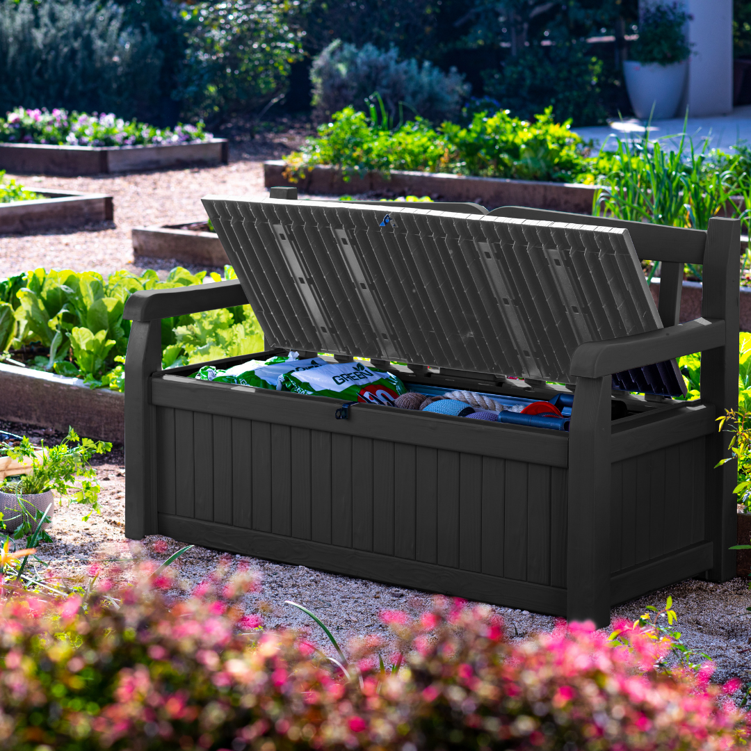Eden 70G Bench Box Graphite with open lid revealing garden supplies and a backrest with armrests in a landscaped garden