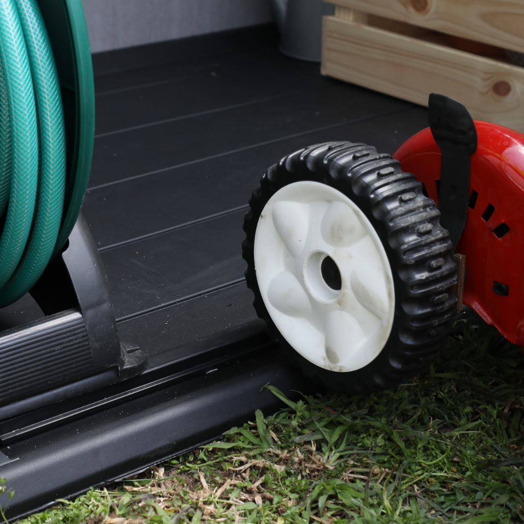 Elite Store close up showing a rugged black resin base beside a garden hose reel and wheeled garden equipment