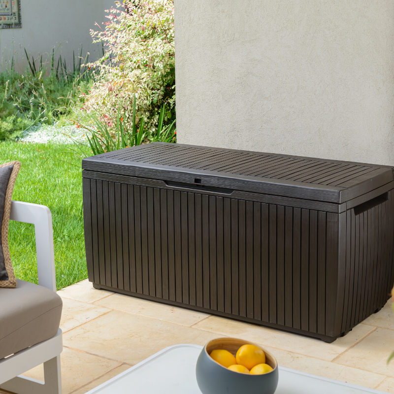Springwood 305L Storage Box in dark brown with a textured slatted lid and vertical panelled sides on a tiled patio
