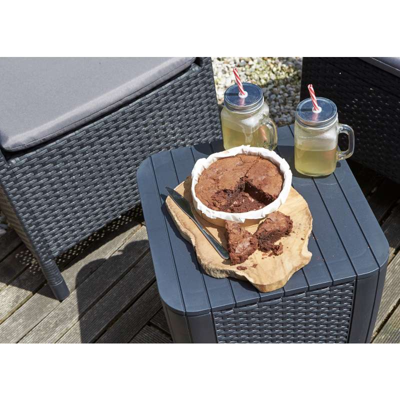 Iowa Balcony Set with dark flat-wicker armchairs and storage side table topped with chocolate cake and two iced drinks on a balcony