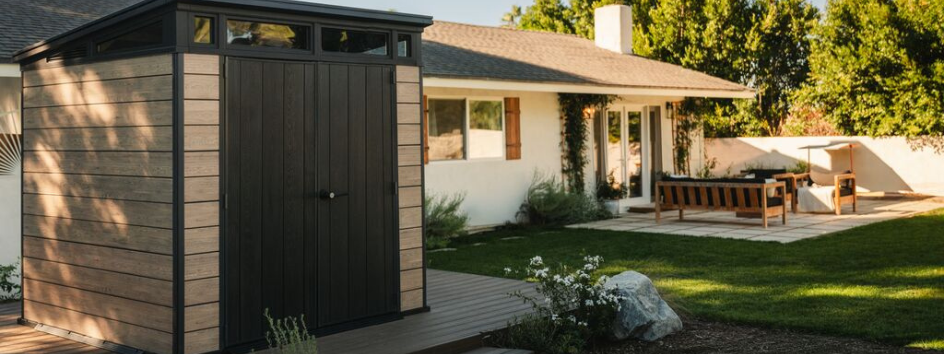 Modern garden cupboard providing secure outdoor storage beside a landscaped backyard and patio.