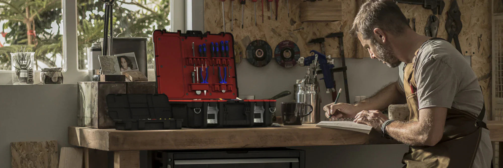 Man working on DIY project with a durable Keter tool box, showing organised portable tool storage for home and garage projects.