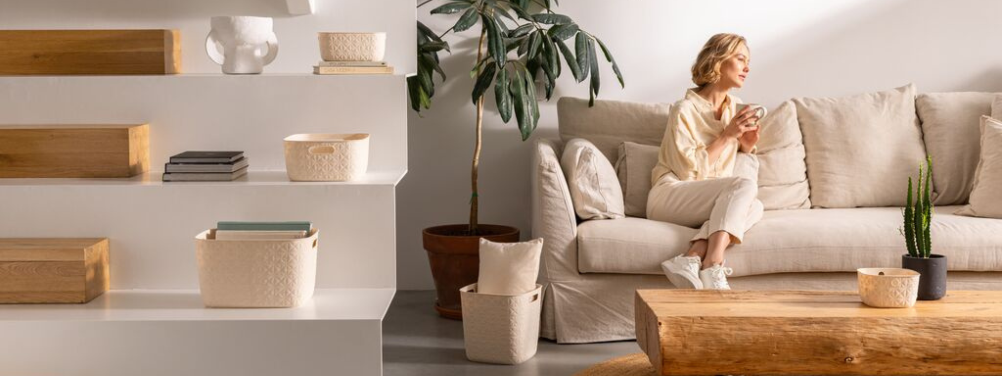 Modern living room with white storage organisers on shelves and a woman sitting on a sofa.