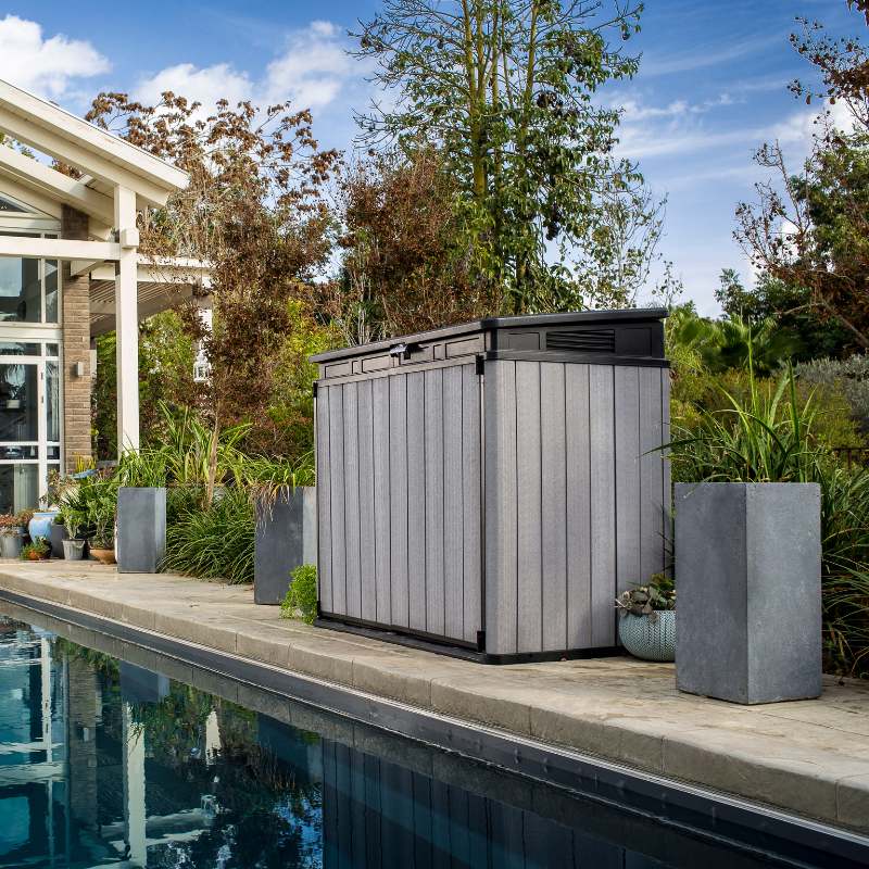 Elite Store grey rib-reinforced resin garden storage unit beside a swimming pool with a low-profile design and surrounding patio plants