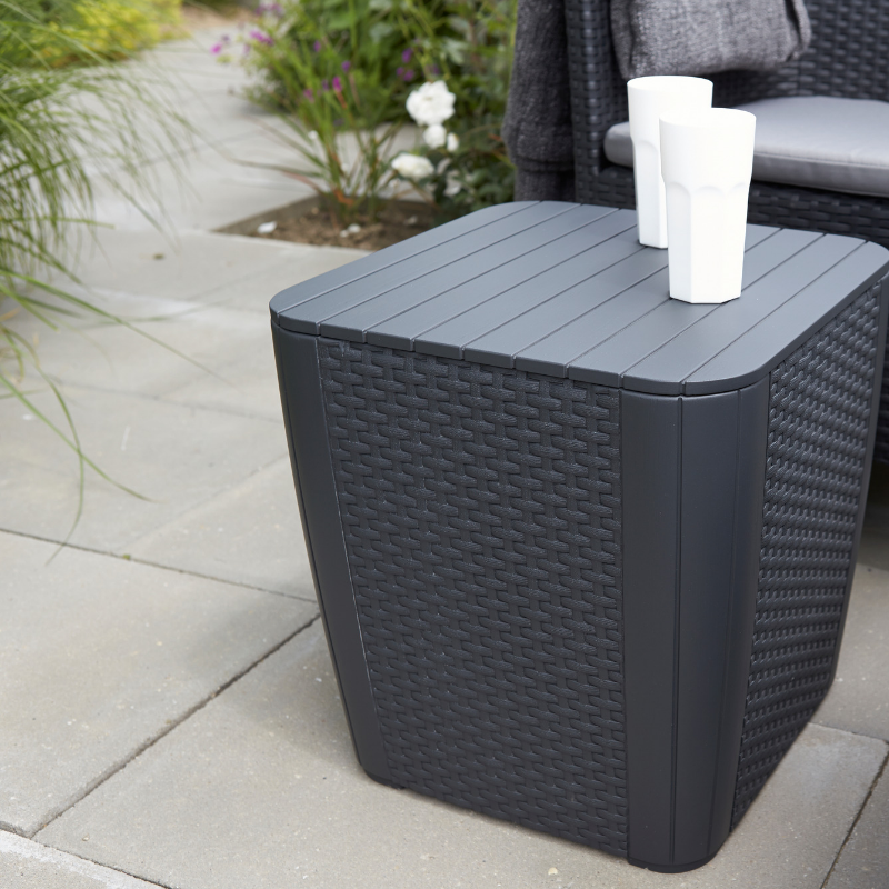 Iowa Balcony Set with a dark flat-wicker resin side table featuring a slatted top beside a matching armchair in a garden setting